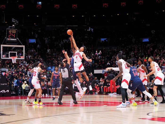 Un joueur de basket-ball saute pour smasher le ballon.