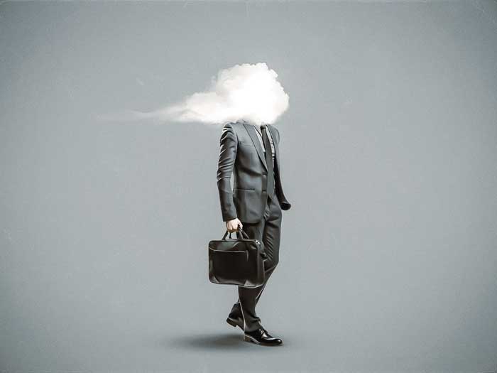 A man in a suit stands with a cloud covering his head
