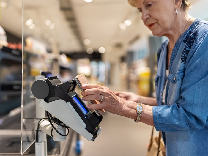 Une femme utilise son téléphone pour un achat en magasin.