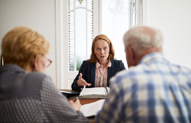Businesswoman Explaining Investment Plan To Retired Couple