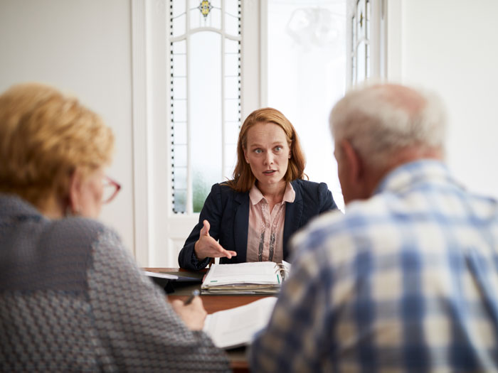 Businesswoman Explaining Investment Plan To Retired Couple