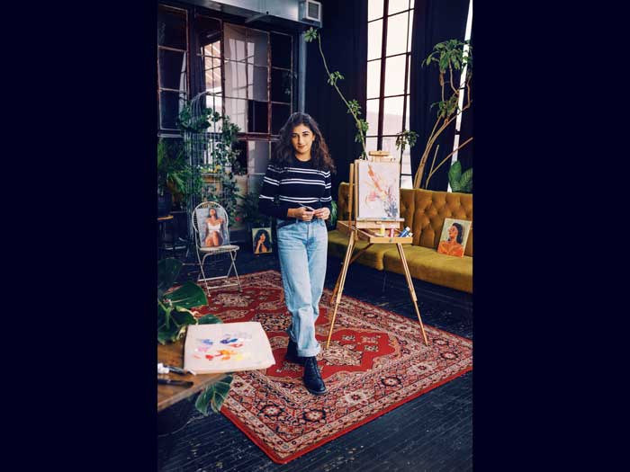 L’artiste et CPA Anisha Kumar se tient parmi ses peintures dans son home studio