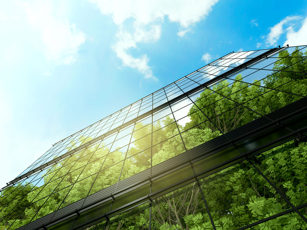 Trees and blue sky are reflected on a 3D rendered business building