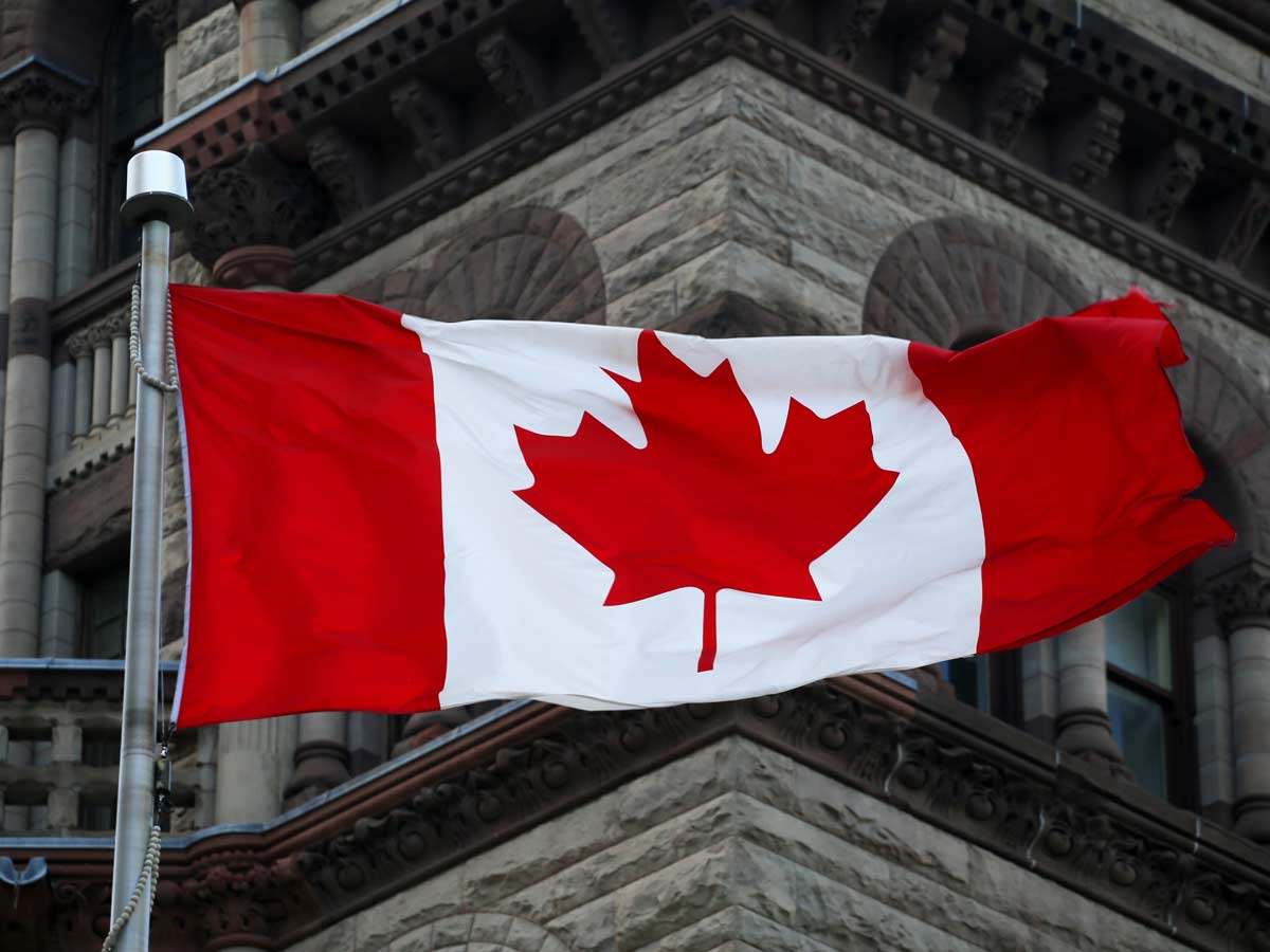 Le drapeau canadien devant les édifices du Parlement