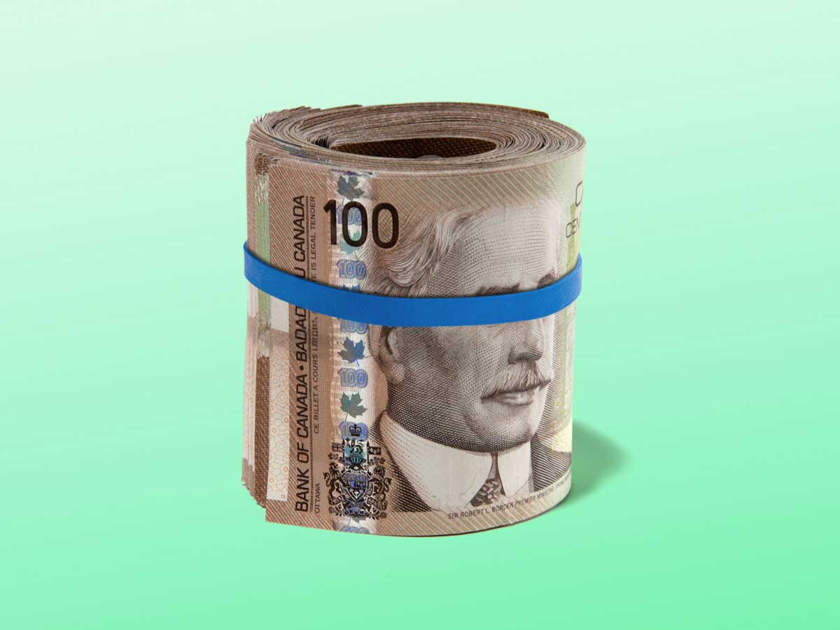 A roll of Canadian $100 bills with an elastic around them that is covering the eyes of the face on the bill