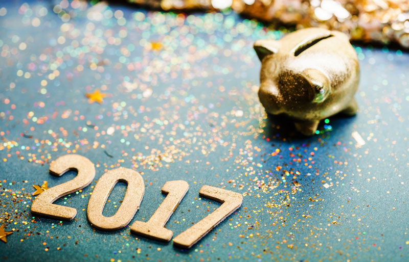 L’année « 2017 » écrite en chiffres dorés et une tirelire en forme de cochonnet doré.