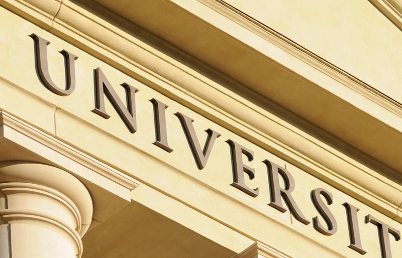 Close-up of the word “university” as it is written on the front of a stately-looking building.