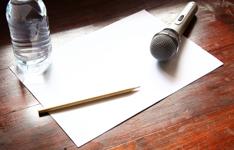 microphone with paper on a brown wooden desk