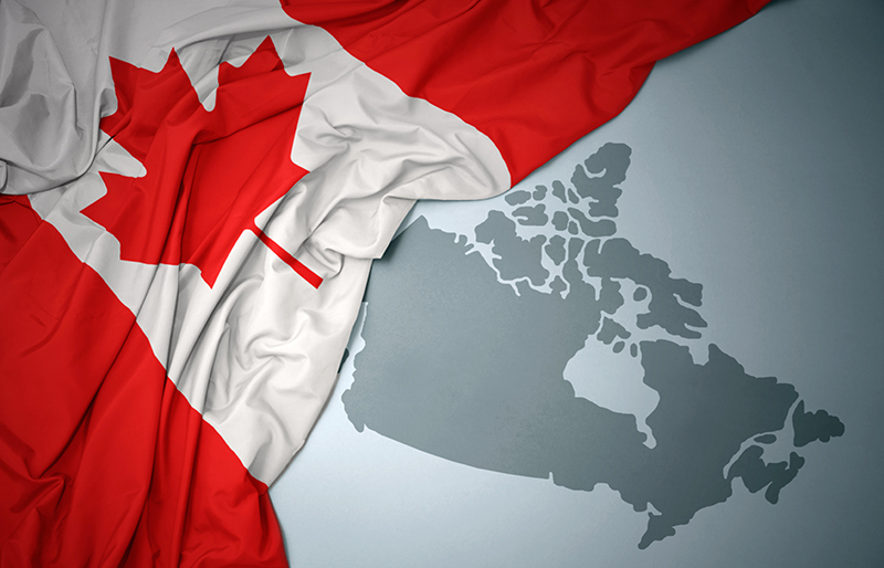 Canadian flag draped over a map of Canada