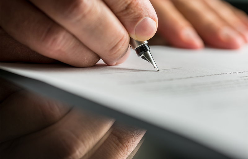 Man signs a document with a fountain pen 