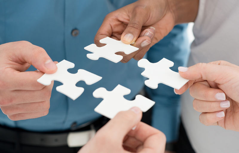 Business people holding puzzle pieces to put together