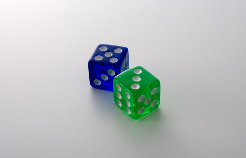 A close-up of two dice, a blue five and a green three.