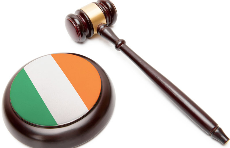 A close-up of a gavel and sound block with the Irish flag colors on it. 