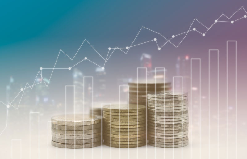 Le monde de la finance et des courtiers en valeurs mobilières est illustré par une image contenant des piles de monnaie, des gratte-ciel en arrière-plan et des graphiques en transparence.