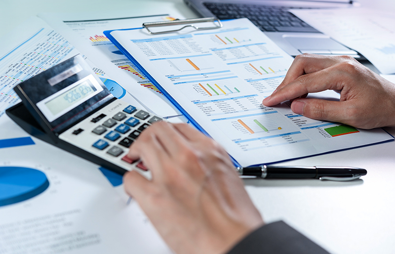 Accountant checking numbers from a business documents with a calculator 