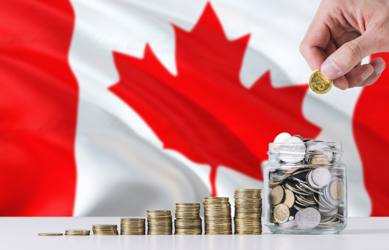 Stacks of coins in front of a Canadian flag.