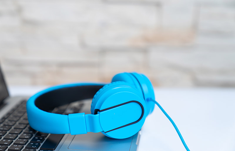 Blue headphones on laptop,Blue headphones - stock photo