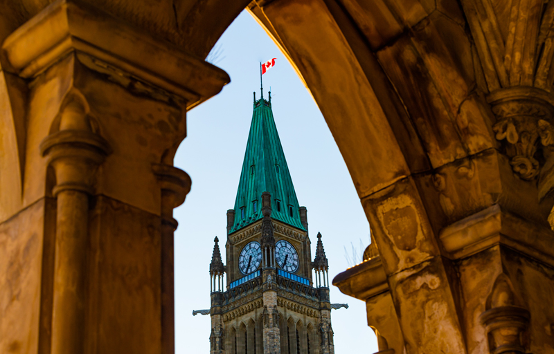 View of Canadian Parliament's peace tower seen through a nearby archway.