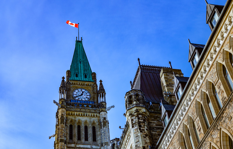 Une illustration du drapeau canadien découpé avec la forme du territoire canadien