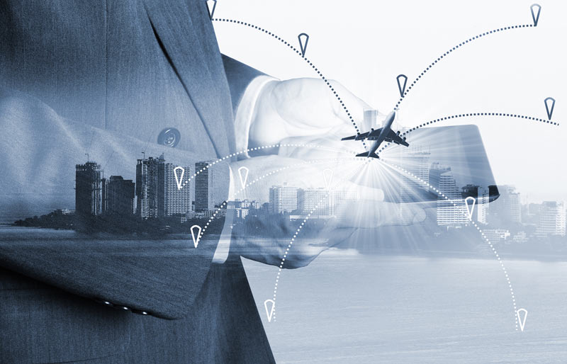 Image conceptuelle montrant un professionnel muni d’une tablette électronique ainsi qu’un avion et des gratte-ciel en transparence.