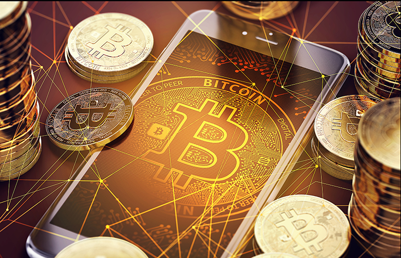 Bitcoin logo displayed on smart phone screen, surrounded by stacks of bitcoins 