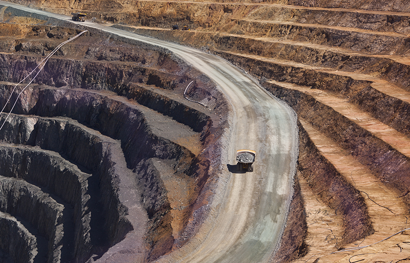Des tombereaux de chantiers transportent du minerai dans une mine à ciel ouvert.