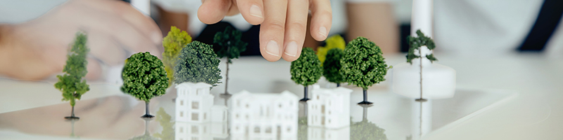 two people urban planning using windmills and miniature models of trees and buildings