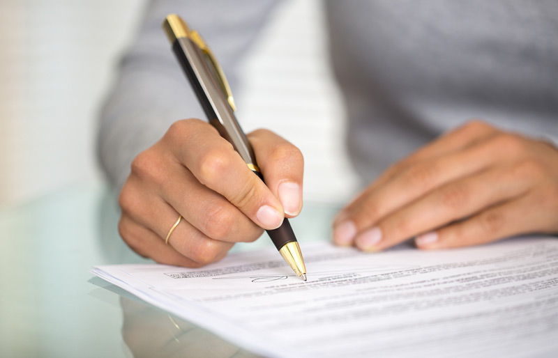 Close up of a businesswoman signing a document.