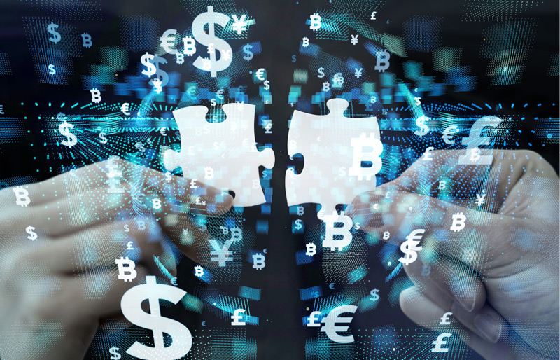 Two hands holding white jigsaw puzzle pieces, on background of technology and currency symbols.