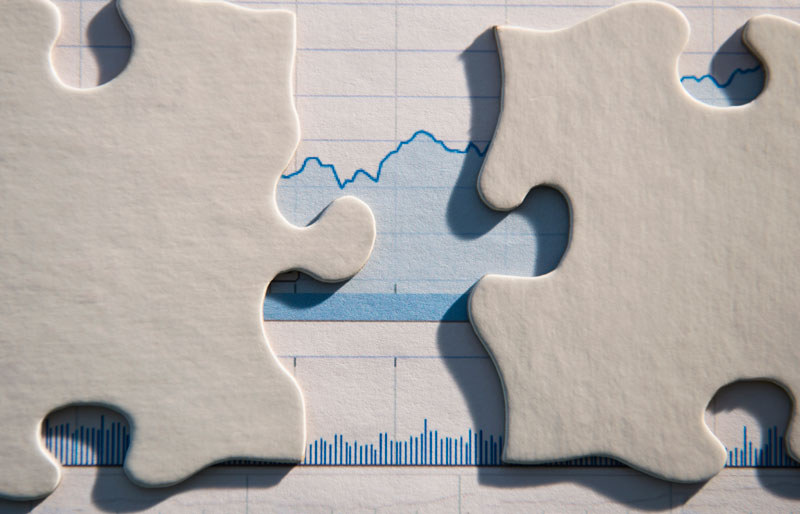 Paper containing a line graph that is partially obscured by jigsaw puzzle pieces.