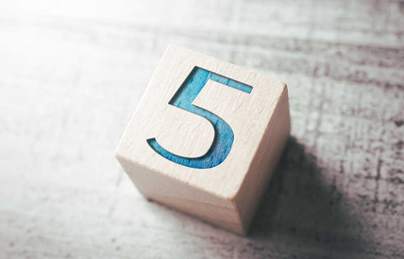 Close-Up Of Toy Block With Number 5 On Table - stock photo