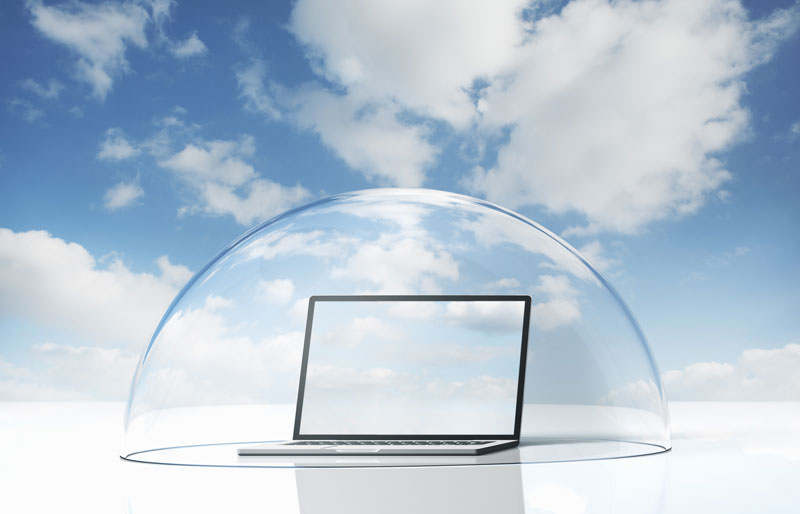 Laptop computer covered by a glass dome, clouds in background.
