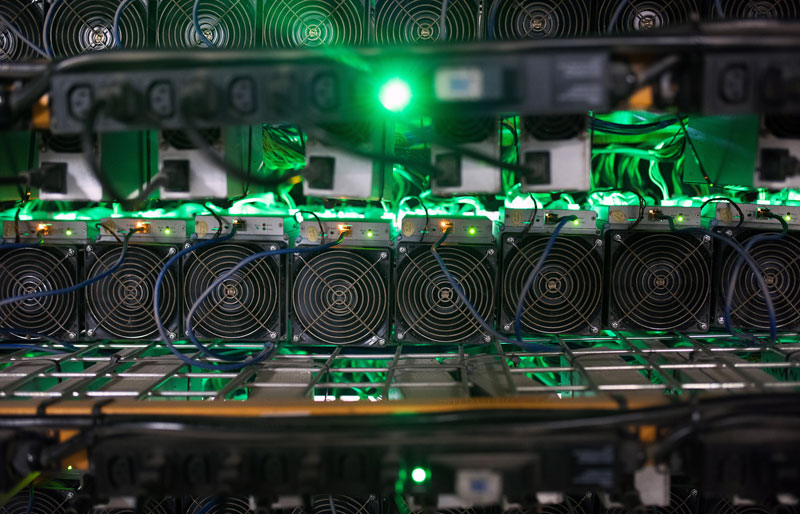Cryptocurrency mining rigs sit on racks at a facility.
