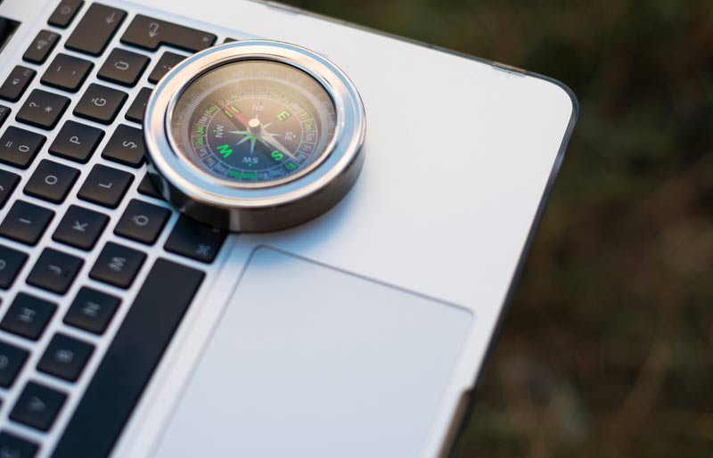 A compass on top of a laptop. 