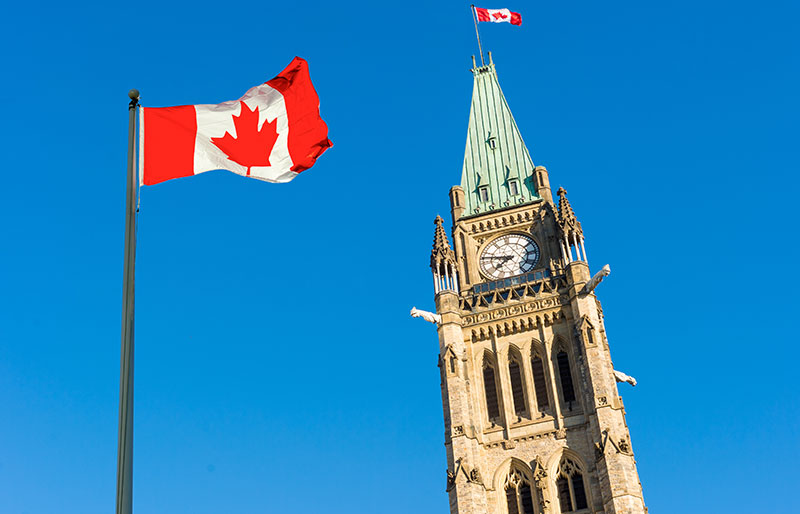 Canadian flag with Parliament buildings in background