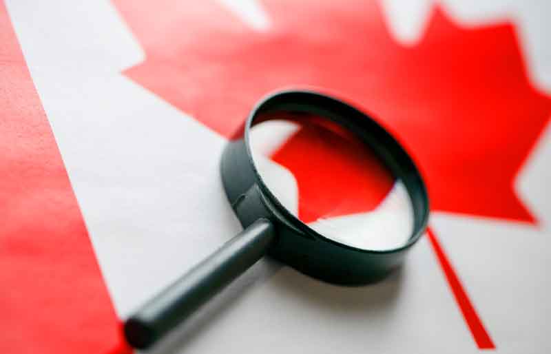 The flag of Canada looks through a magnifying glass