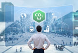 Businessperson standing in front of a screen displaying sustainable business icons