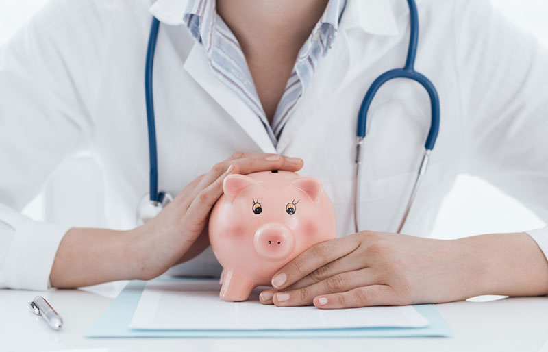 Female doctor holding a piggy bank