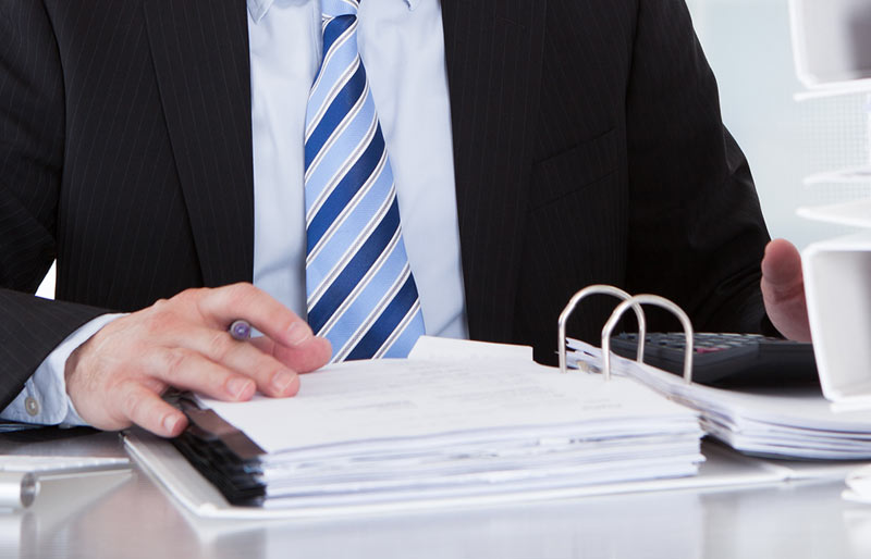 A close-up of a business professional reviewing a report. 