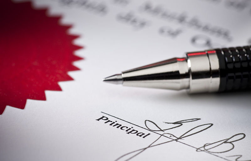 Gros plan d'un contrat montrant une signature et un sceau, un stylo est déposé sur le document.