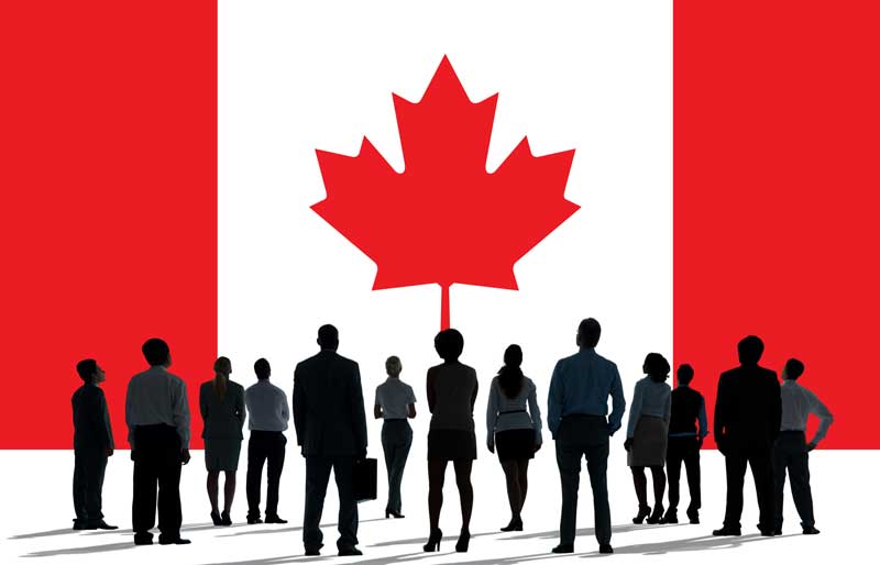 Canada flag with group of people looking at it