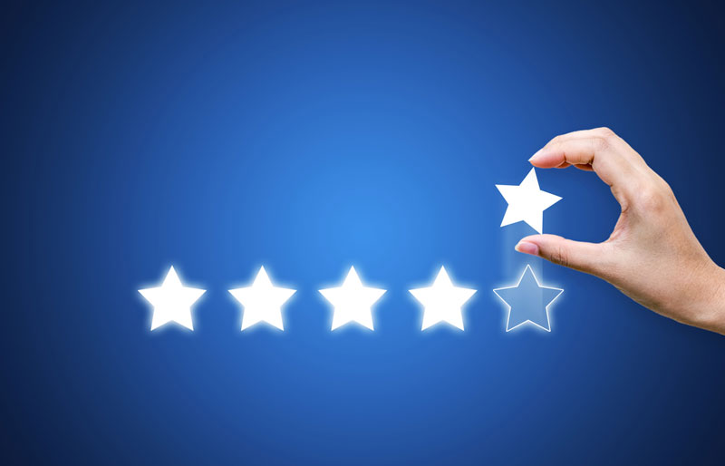 A person's hand placing a star to complete a row of five stars.