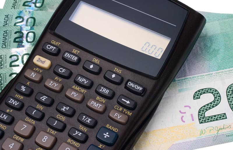 A calculator and a pile of Canadian twenty-dollar bills.